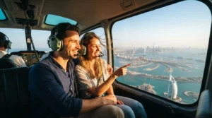 A couple enjoying a scenic helicopter ride for couples Dubai during golden hour, admiring the coast below.