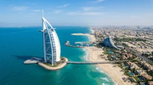 Aerial daylight view of the sail-shaped Burj Al Arab on its island off the Jumeirah coast, with turquoise sea around it